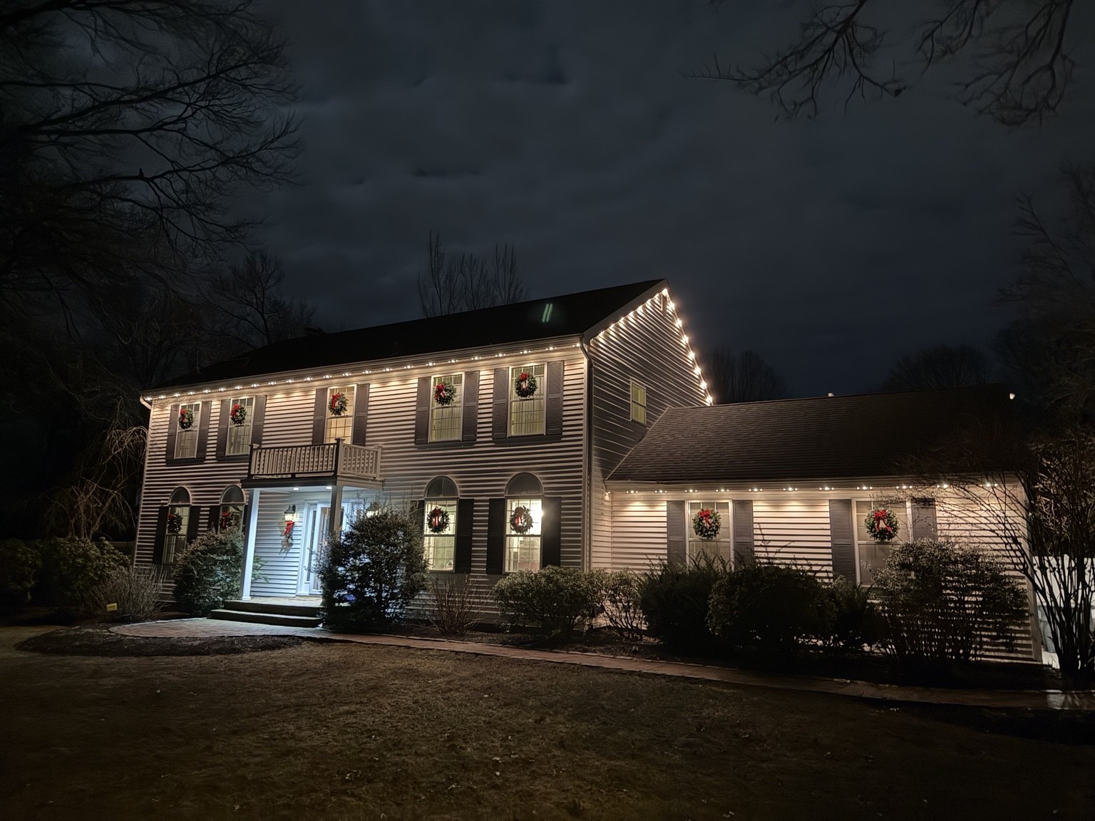 White permanent roofline lighting on a colonial home