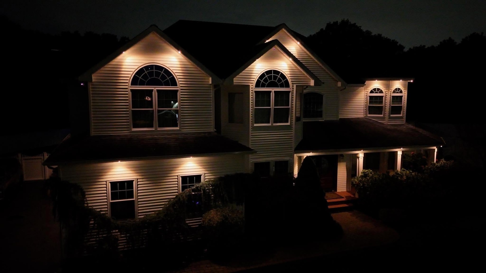 JAS Lighting installation highlighting a home's peaks and siding with warm white light