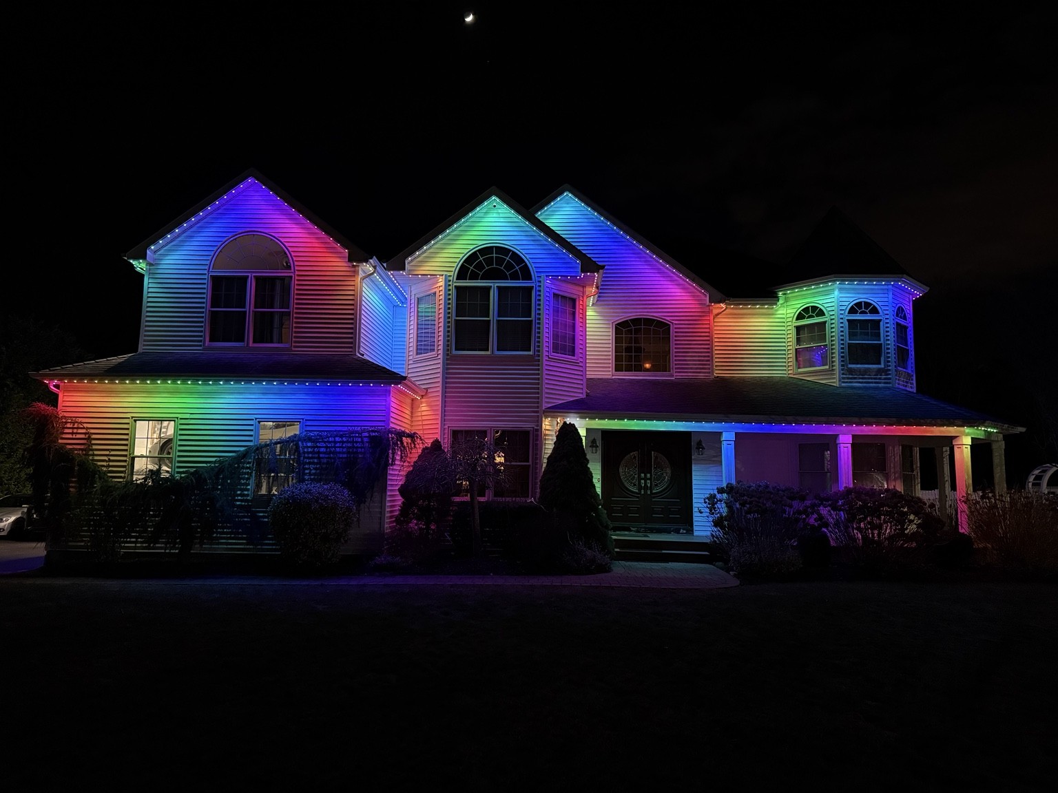 The same JAS Lighting home illuminated in full rainbow color