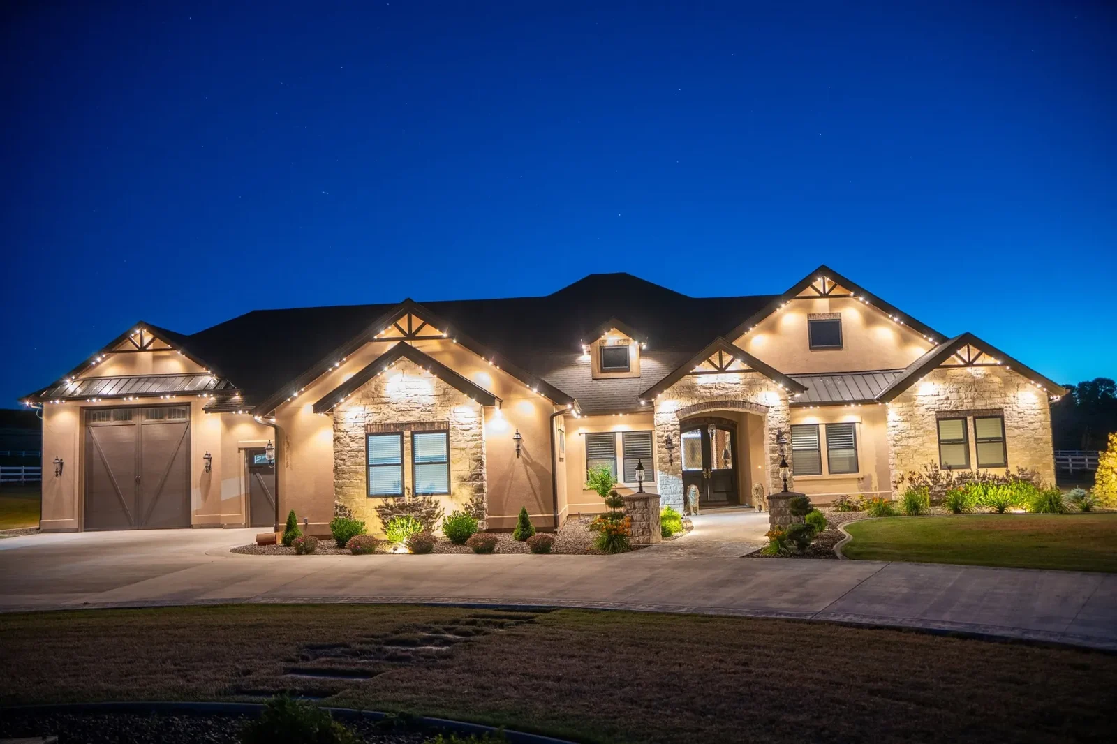 Home with warm-white lighting highlighting its peaks and roofline
