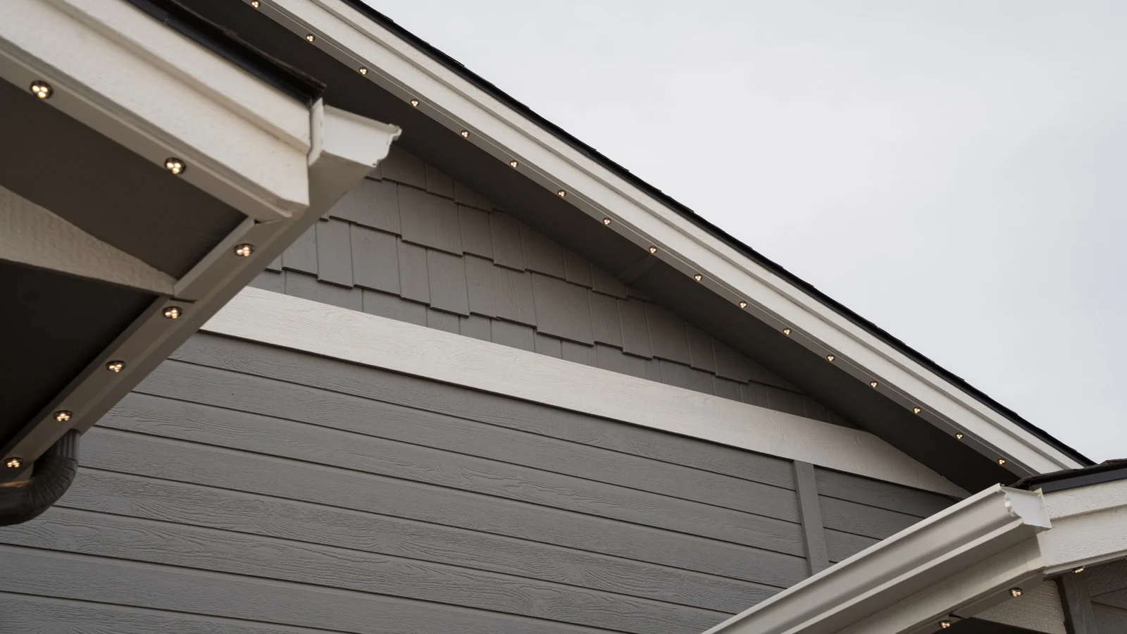 Color-matched track following a home's peaks in daylight, with warm-white LEDs illuminated